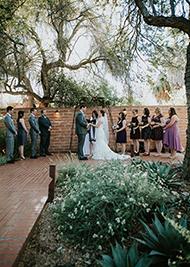 Photo of a bride and groom kissing with the desert in the background